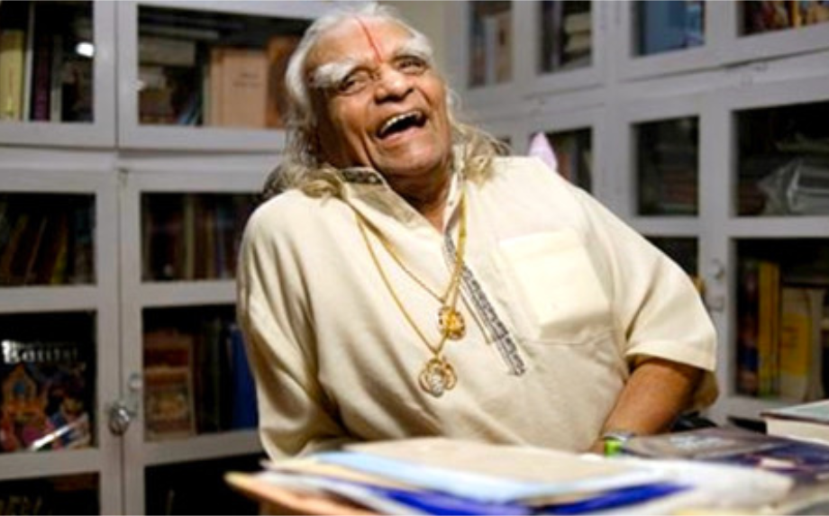 B.K.S. Iyengar lachend in seiner Bibliothek